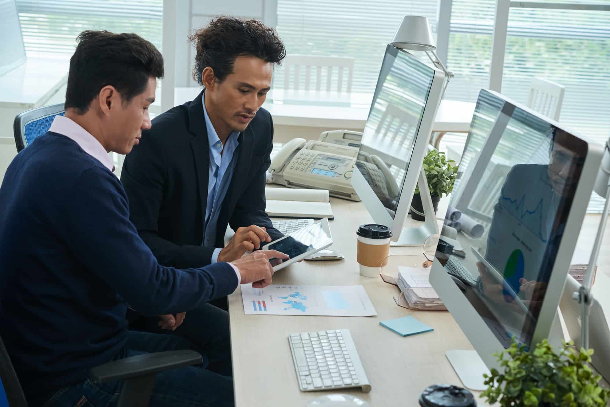 businessmen-working-with-finance-data-on-tablet.jpg